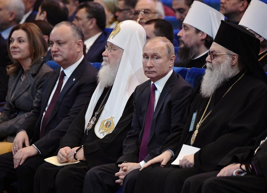 Putin sits with head of heads of Orthodox church. 