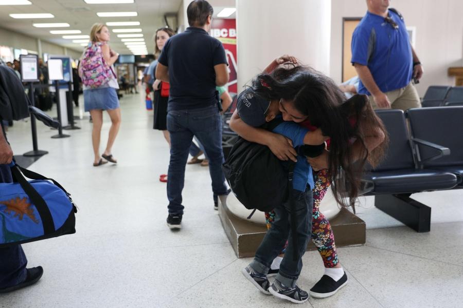 A mother hugs her son in the airport