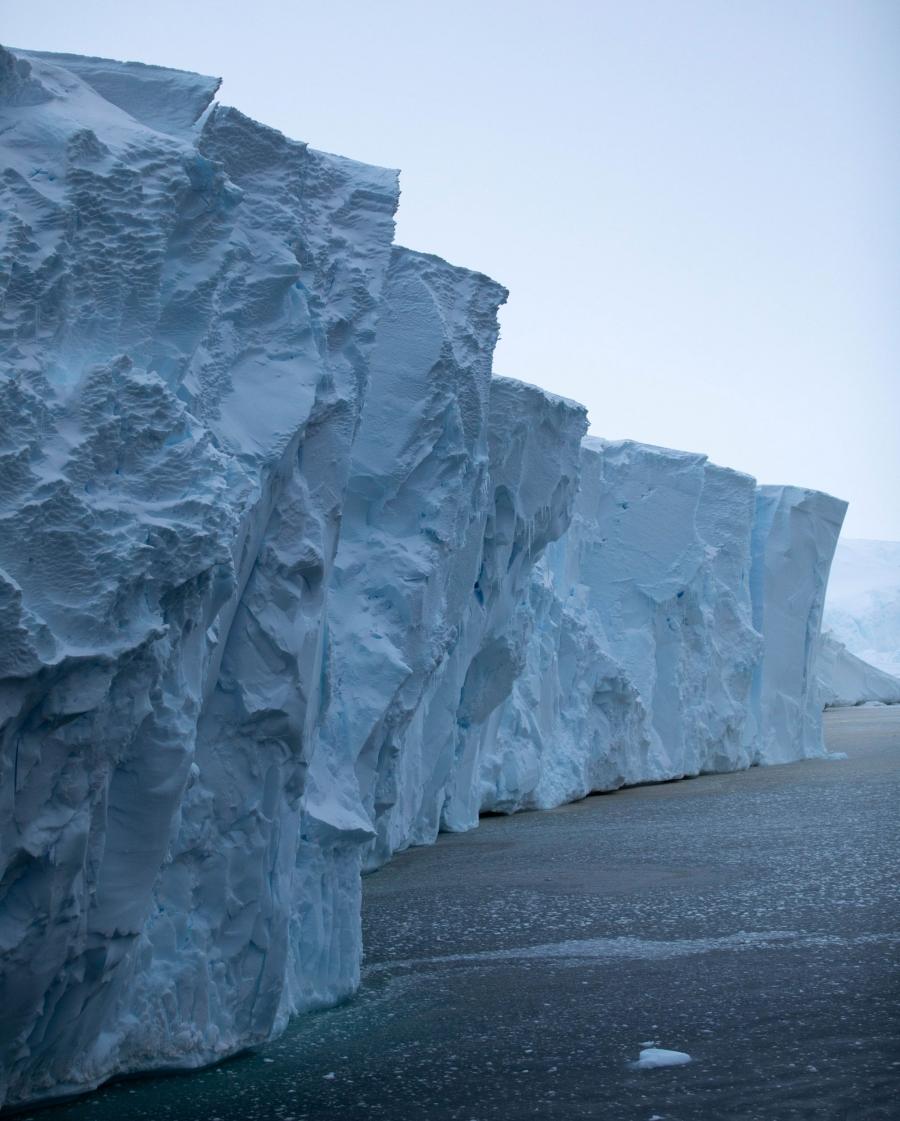 The front face of Thwaites glacier is shown rising an estimated 60 to 75 feet above the dark blue ocean waters.