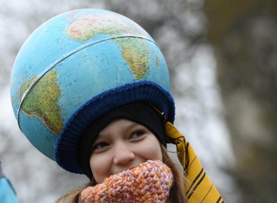 A young demonstrator is shown wearing a globe as a hat.