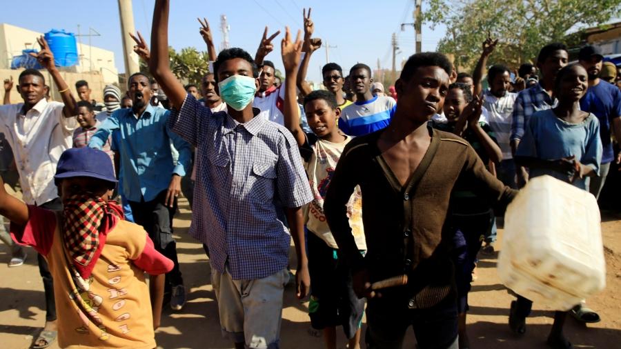 Youth protest wearing wearing bandanas on their faces and carrying a can in Khartoum. 