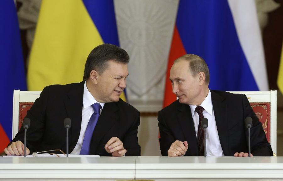 Former Ukrainian President Viktor Yanukovich, left, gives a wink to his Russian counterpart Vladimir Putin