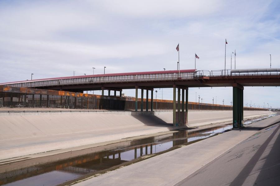 A bridge is shown horizonally across the image with US and Mexican flags in the middle.