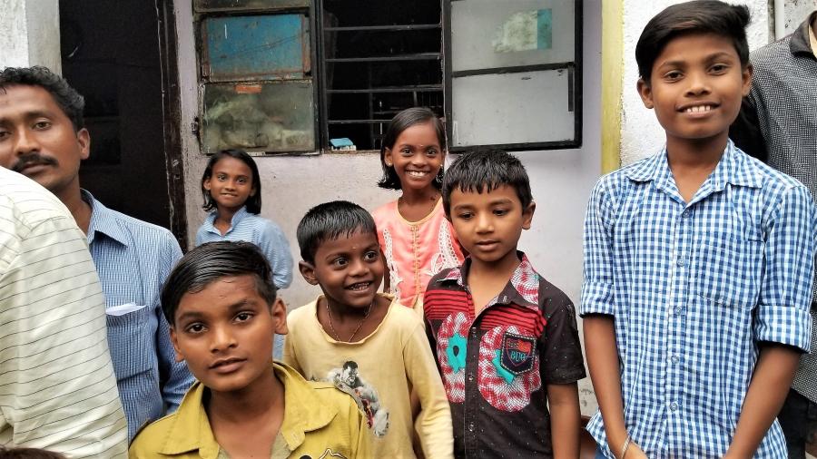 Several Indian children look toward the camera, some smiling proudly. 