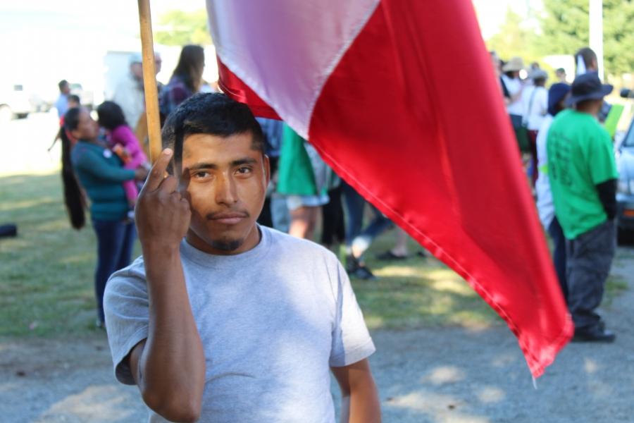 Man with flag in front of protesters