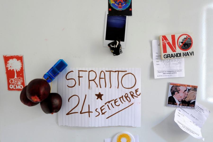 A note on line paper is seen on a white refrigerator with "Sfratto 24 Settembre" written on it.