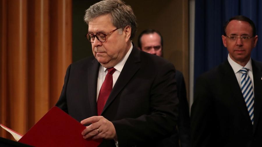 William Barr is shown standing with a red folder