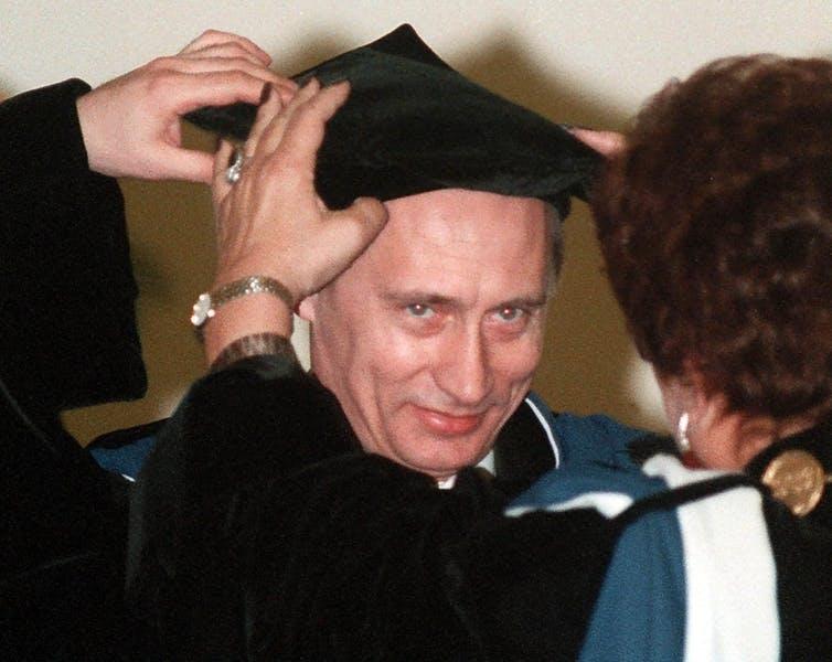 Vladmir Putin is pictured wearing a graduation cap. 