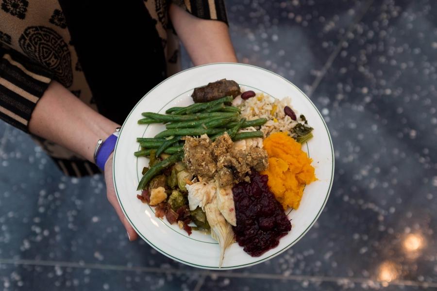 A guest of Thanksgiving FEAST shows off the colors of her plate
