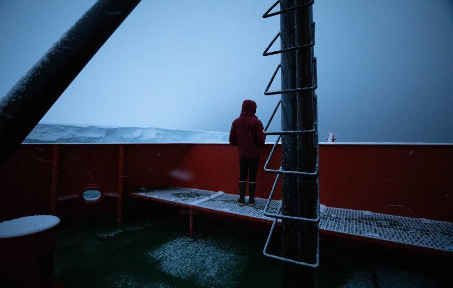 Oceanographer Peter Sheehan is shown with his jacket hood over his head while looking out at Thwaites. 