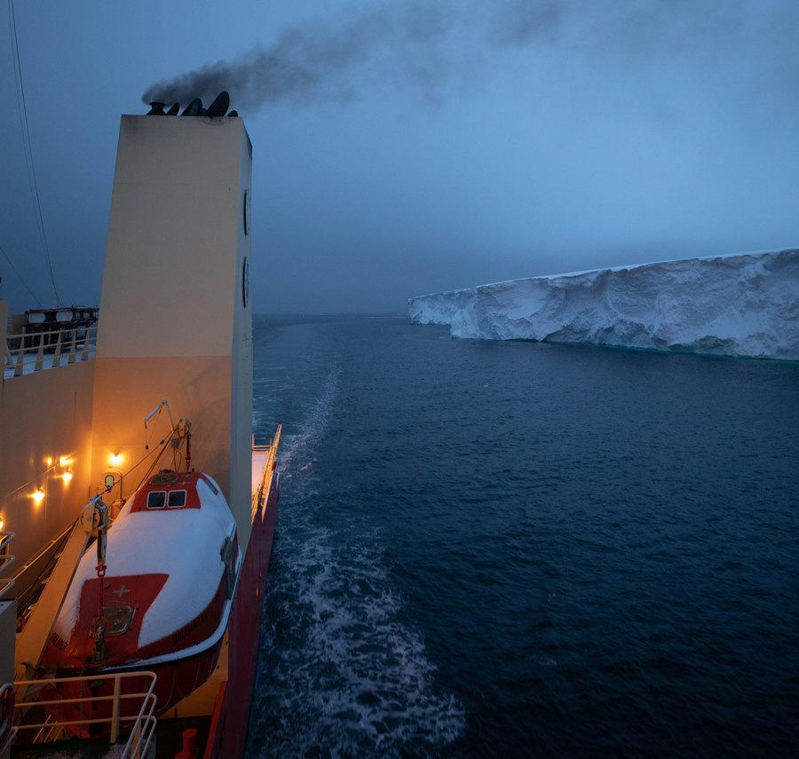 From the side of the vessel, the Nathaniel B. Palmer is shown with a smoke stack in the nearground, navigating along the eastern tongue of Thwaites glacier.