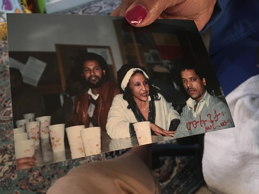 Endeyu Kendie holds a picture of one of the Ethiopian community's parties in the 1980s, with Mulugeta Seraw pictured at right.
