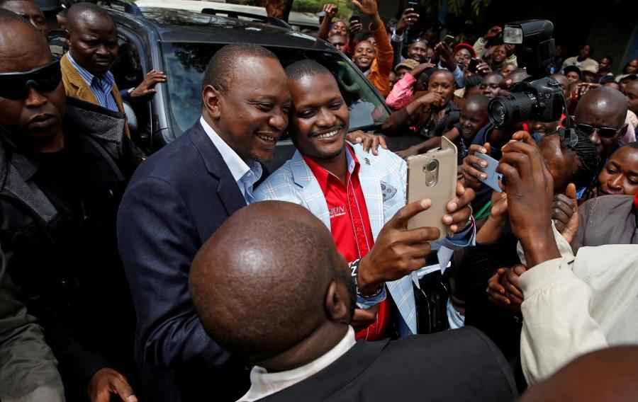 Kenya's President Uhuru Kenyatta poses for pictures with supporters after casting his vote during the presidential election re-run in Gatundu, Kenya, Oct. 26, 2017.