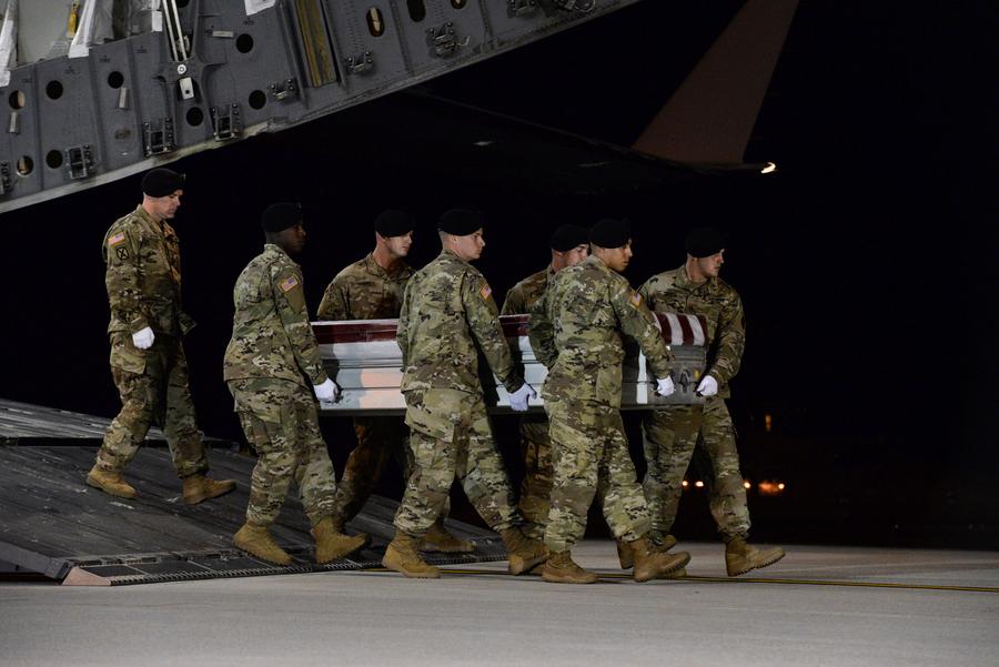 A US Army carry team transfers the remains of Army Staff Sgt. Dustin Wright moving the casket off of an aircraft.