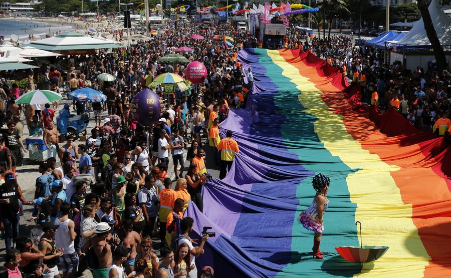A participant performs on a giant rainbow flag during a Gay Pride Parade at Copacabana beach in Rio de Janeiro on Nov. 16, 2014.