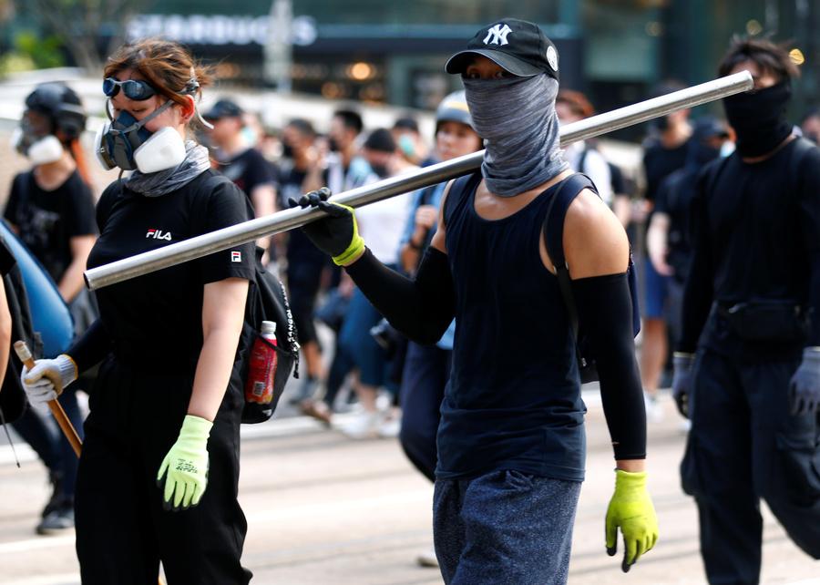 A protester carries an iron bar outside Causeway Bay station in Hong Kong