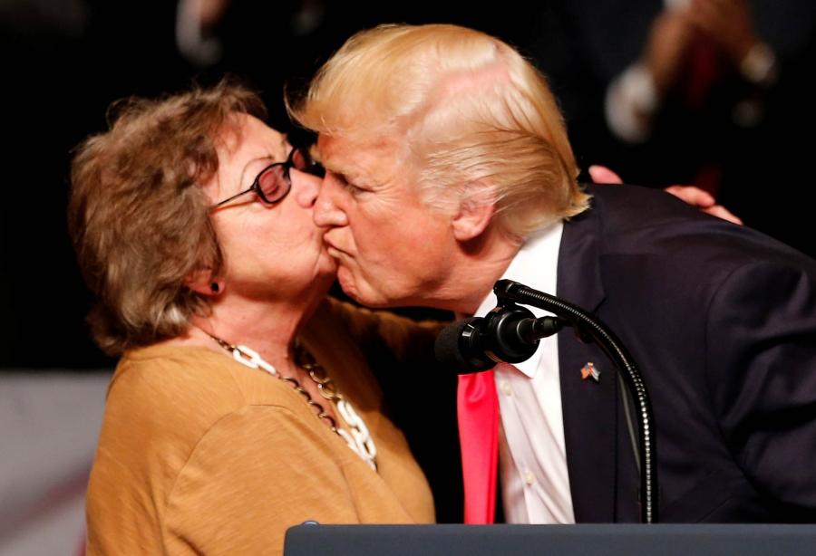 US President Donald Trump receives a kiss from Cuban dissident Cary Roque at an event where he announced his Cuba policy at the Manuel Artime Theater in the Little Havana neighborhood in Miami, Florida, June 16, 2017.