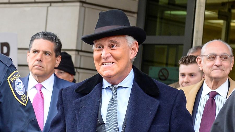 A man smiling in a hat surrounded by people