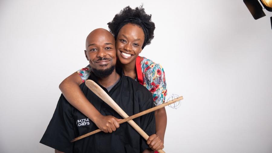 A black man and a black woman pose in a hug for a publicity photo of the film "Cook Off"