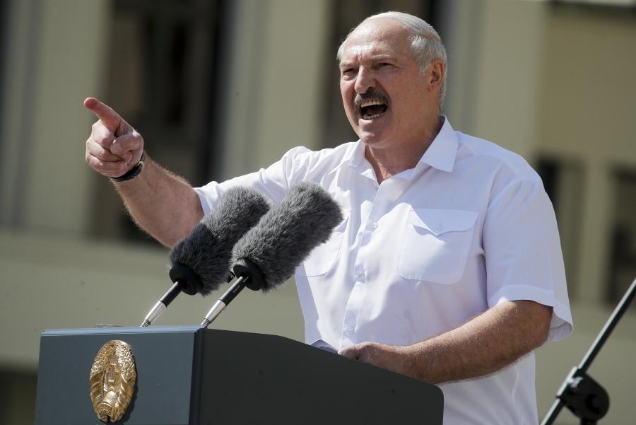 Alexander Lukashenko passionately speaks into a microphone, with his hand up and finger waving at the audience. 