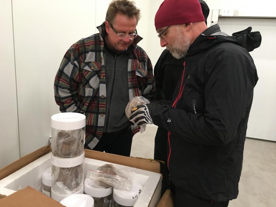 Geomorphologist Paul Bierman (right) and geochemist Joerg Schaefer of Columbia University examine the jars holding Camp Century sediment for the first time. They were in a Danish freezer set at -17 F.