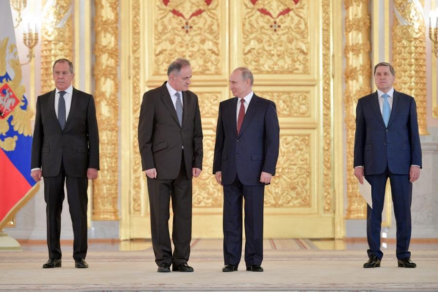 Four men stand in a line – the two in the middle at Montenegro's ambassador to Russia and Vladimir Putin 