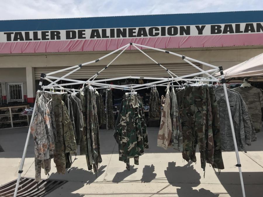 Racks of camouflage clothing outside a tire alignment shop