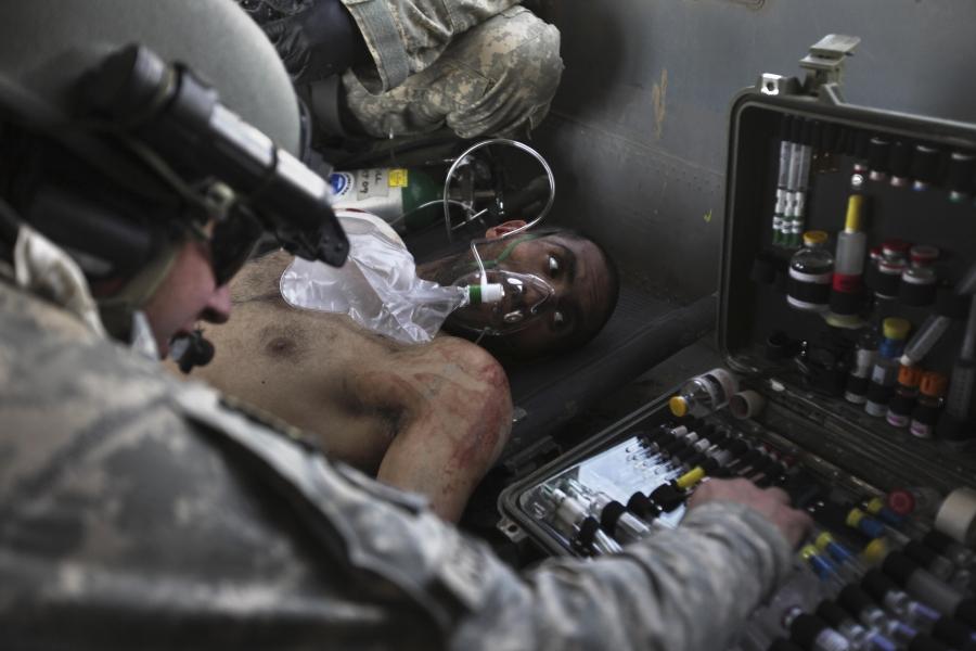 Airborne in a US Army Task Force Pegasus helicopter, US Army Staff Sgt. and flight medic Robert B. Cowdrey, of La Junta, Colo., gives medical care to an Afghan National Army soldier with a gunshot wound, during a medevac mission over Marjah, Helmand provi