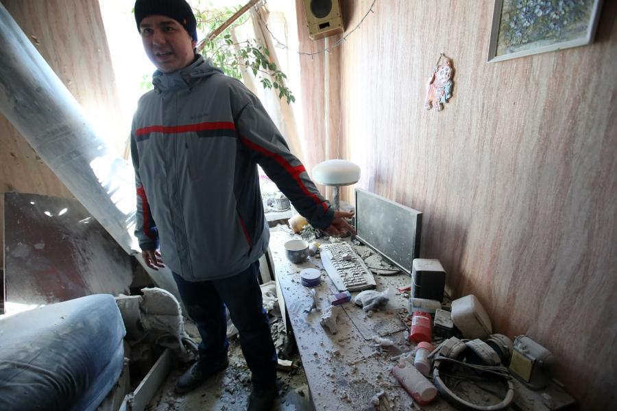 A man shows the impact of a shelling by Russian troops in northeastern Ukraine on Feb. 24, 2022. 