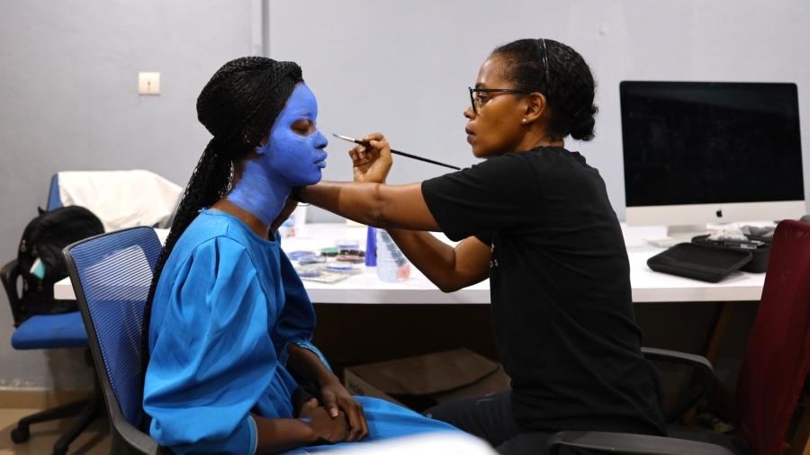 Photographer Aïda Muluneh prepares a model for a photo shoot in Abidjan, Ivory Coast. She paints the model's face blue.