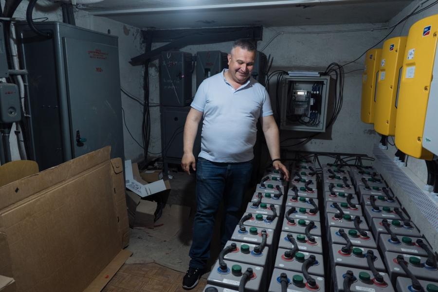A man showing a row of solar energy batteries.