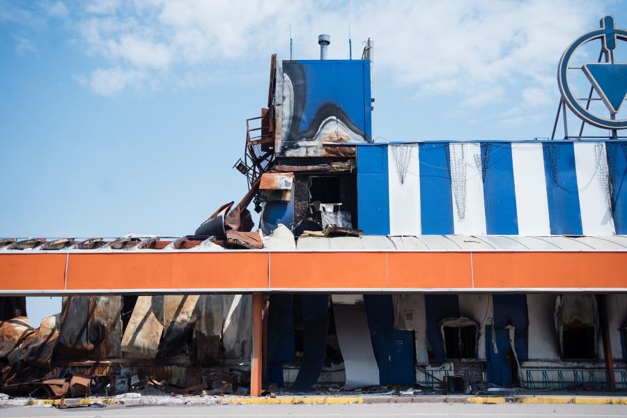A destroyed store with blue and white stripes and orange accents