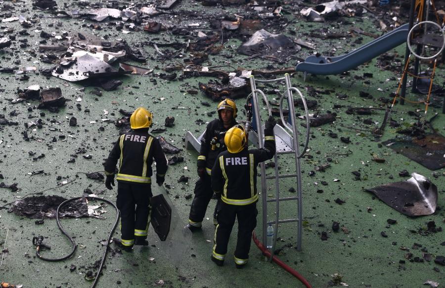 Firefighters stand amid debris in a childrens playground