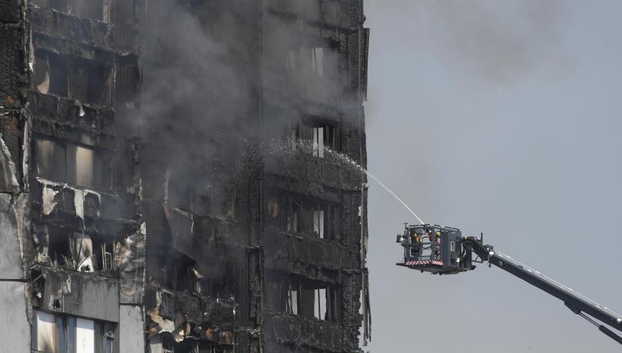 Firefighters direct jets of water onto a tower block severely damaged by a serious fire