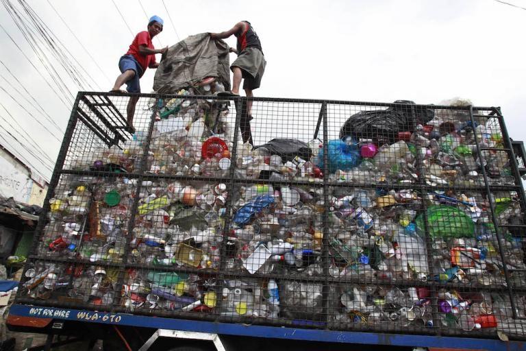 Workers load collected plastic bottles onto a truck in Manila in the Philippines, March 10, 2015.  