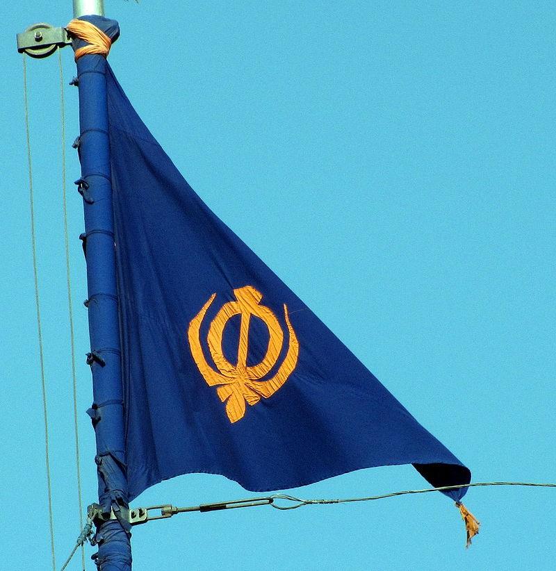This Sikh flag, called the Nishan Sahib, is a another triangular flag from South Asia. It's made of cotton or silk cloth, with a tassel at its end. The word Nishan means symbol, and the flag is hoisted on a tall flagpole, outside most Gurdwaras, the place