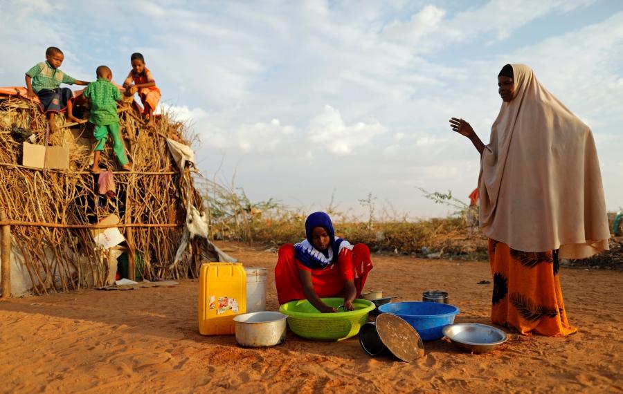 Zeinab, 14, washes dishes alongside her mother Abdir Hussein while her nephews play at a camp for internally displaced people in Dolow, Somalia April 3, 2017. 