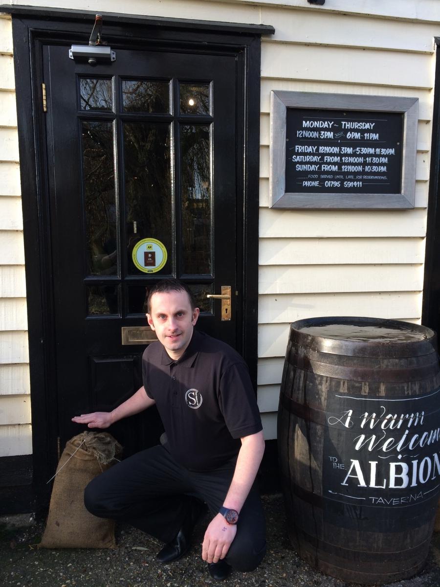 Gareth Finney shows the level of the floodwaters in his pub in Faversham England