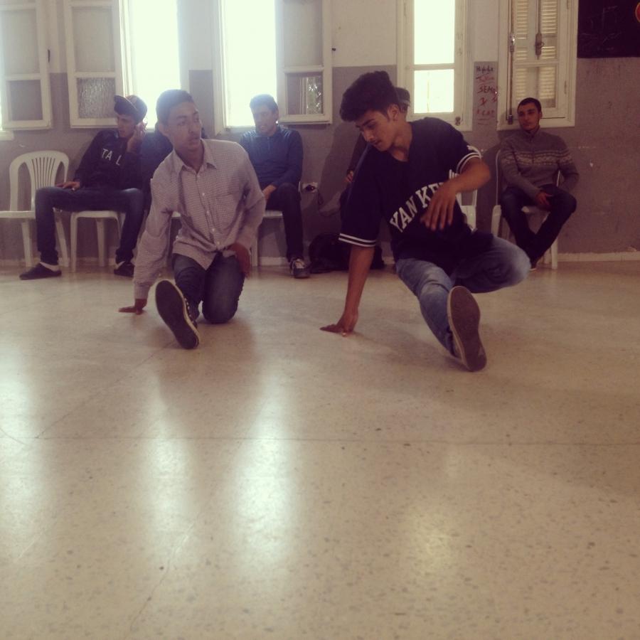Ilyesse Gharbi, 17, teaches another teenager the basic footwork of break dance.