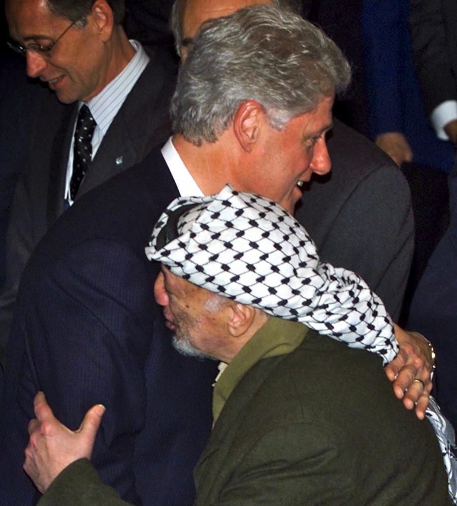 U.S. President Bill Clinton hugs with PLO Chairman Yasser Arafat in Davos, Switzerland, January 29, 2000. 