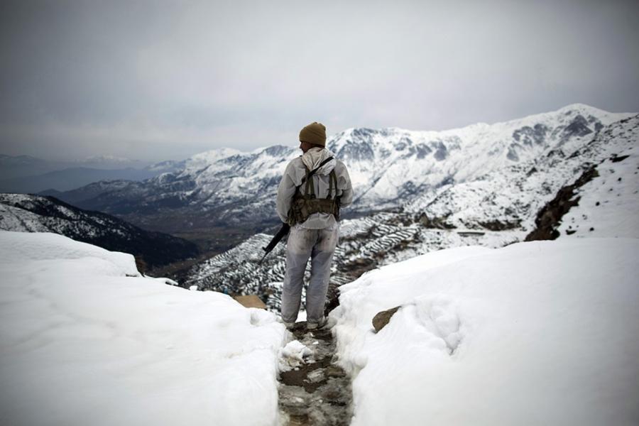 A Pakistani stands atop the 8000-foot mountain during a patrol near his outpost, Kalpani Base, on the Pakistan-Afghan border, on Feb. 17, 2012.