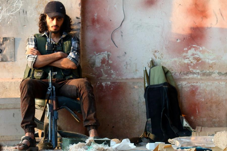 A rebel fighter sits with his weapon in the artillery academy of Aleppo, Syria, August 6, 2016.