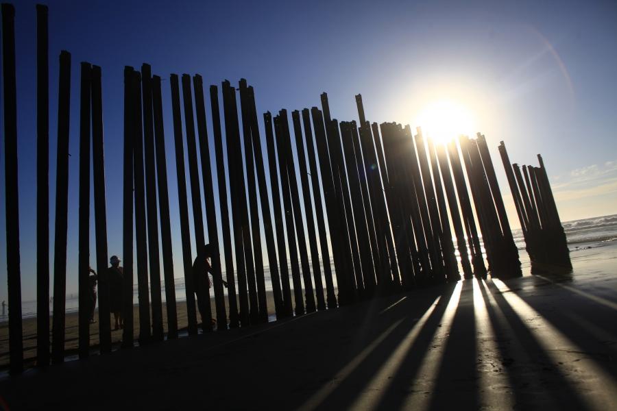 People stand at a wall separating Mexico and the United States in Tijuana as photographed from Imperial Beach, California, Nov. 5, 2010.