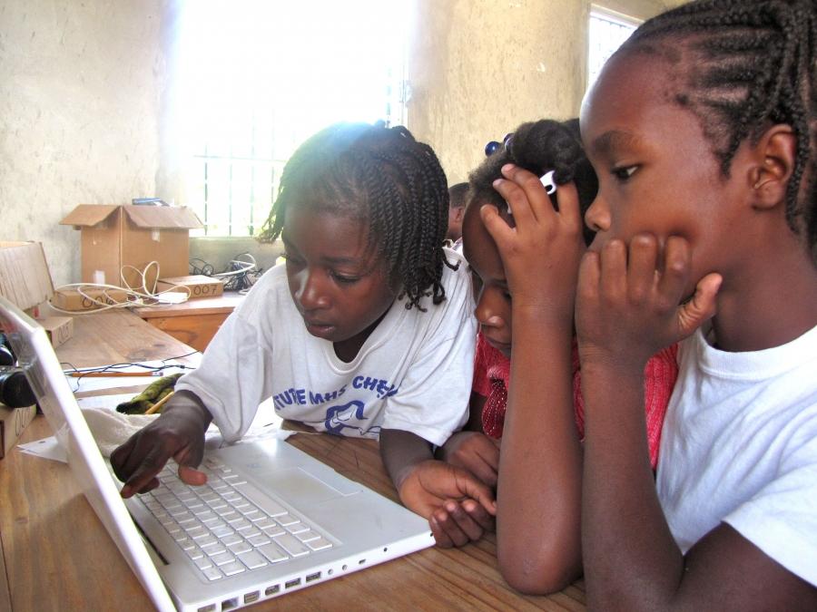 Frandy Calixte, at right, and classmates at the Matenwa Community School learn numeration by playing a pirate video game translated into Creole by linguist Michel DeGraff and his team at MIT.
