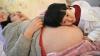Li Yan, pregnant with her second child, lies on a bed as her daughter places her head on her mother's stomach in Hefei, Anhui province February 20, 2014. 