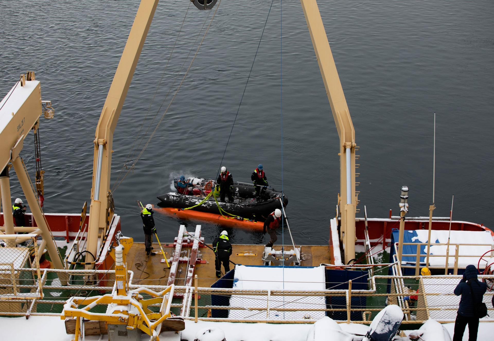 The Hugin submarine is shown getting tied to a winch cable.