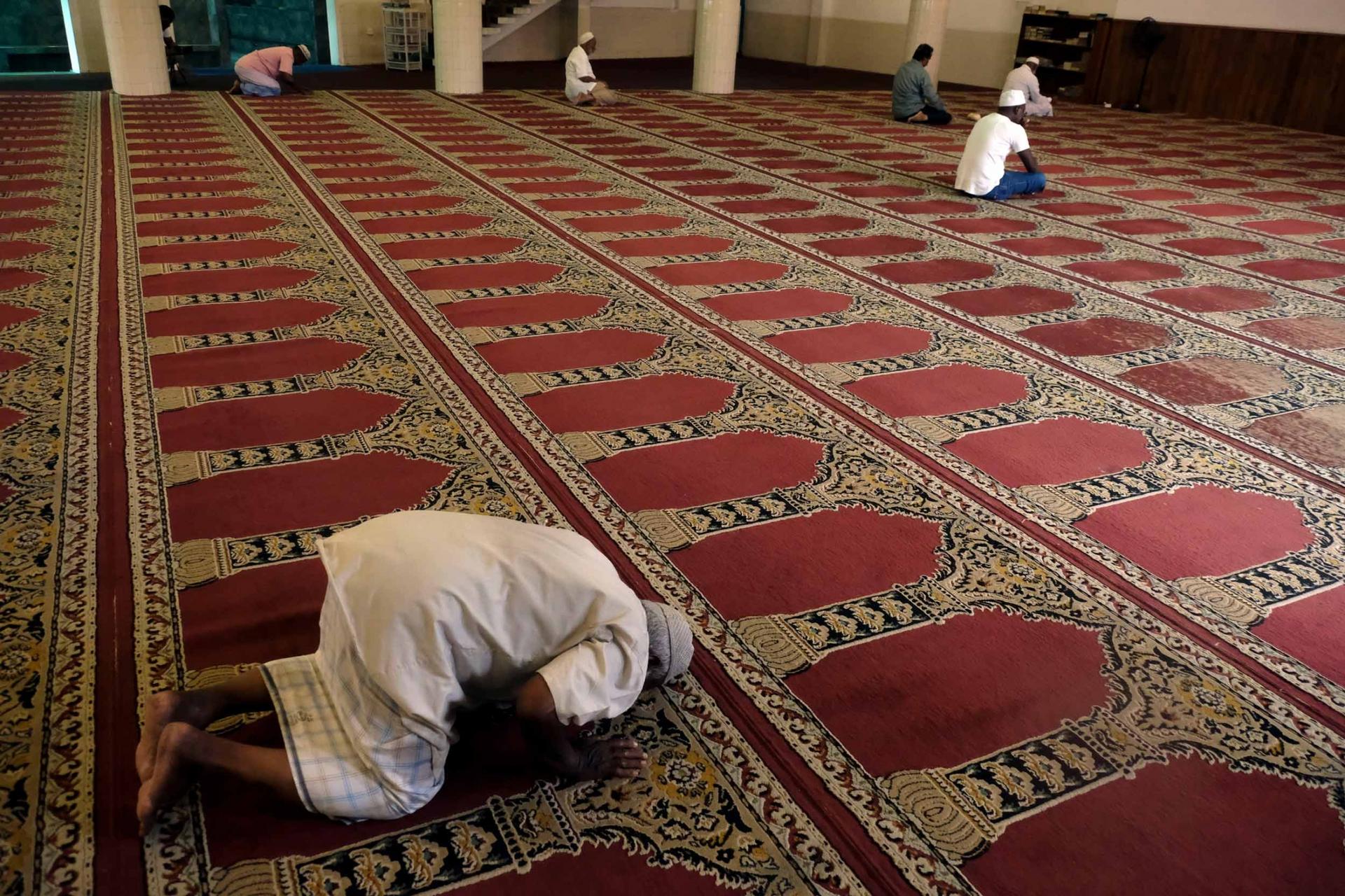 A few men are praying in a mosque