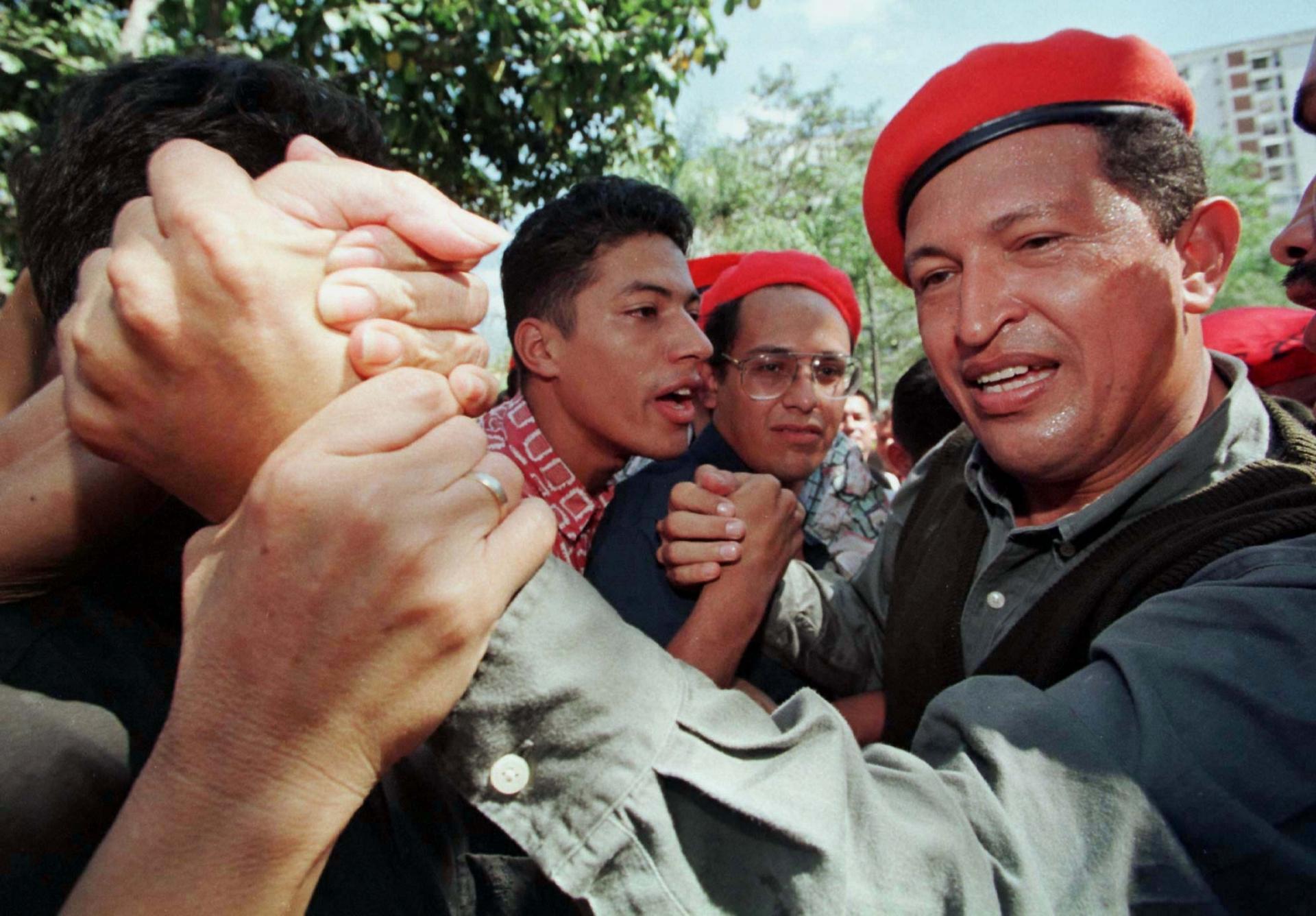Chavez wearing red beret shakes hand of supporter