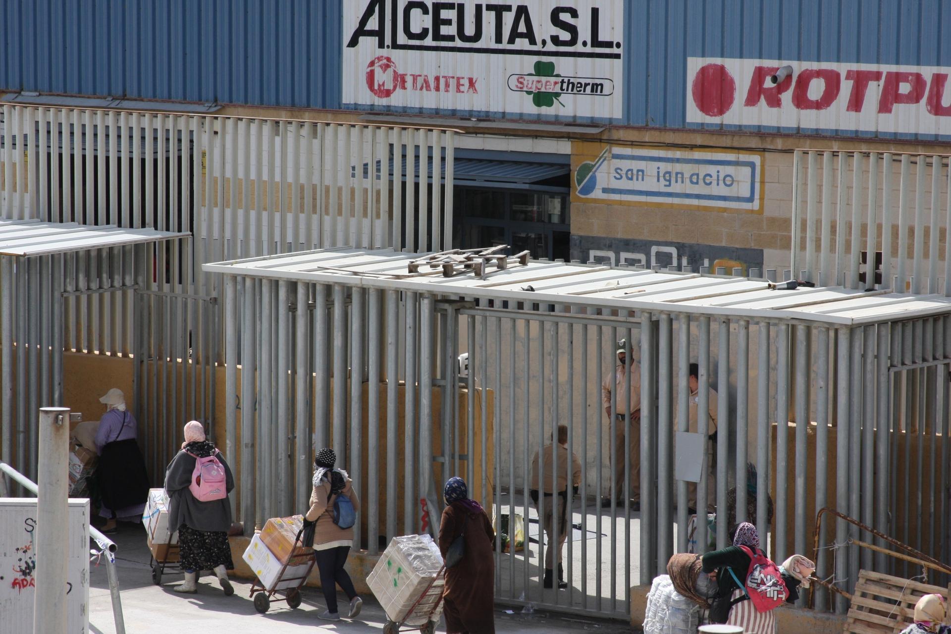 women line up to enter metal gates into spain