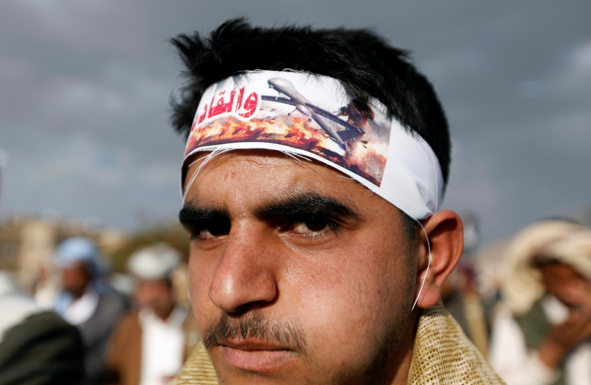Young man wears headband showing image of drone attack